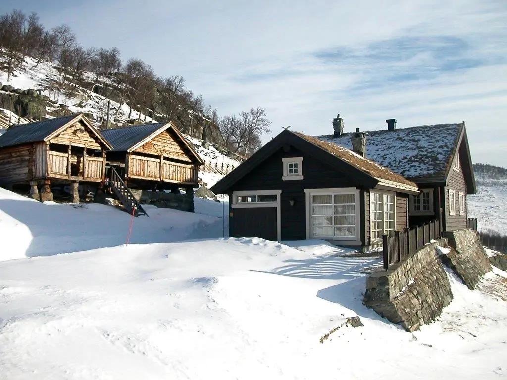 Two cabins in snow, one with a garage