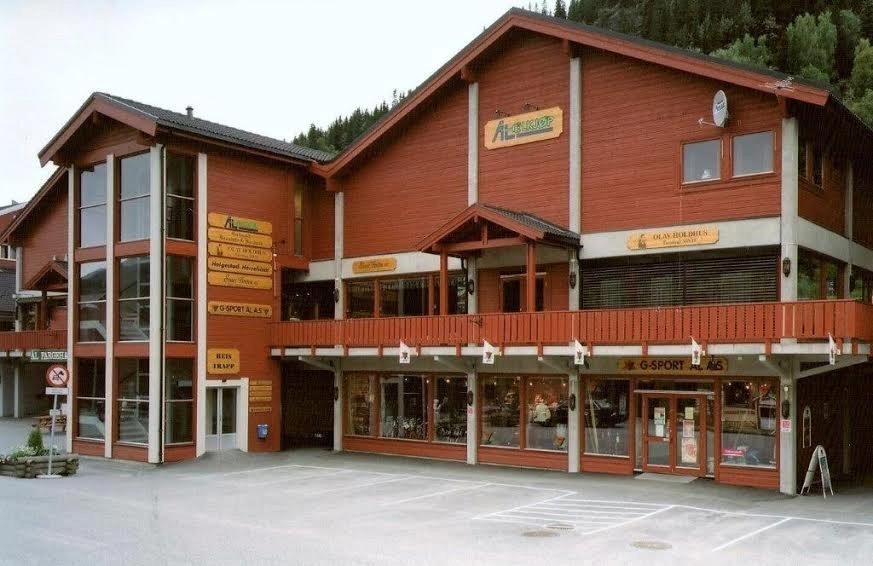 A large red-stained shop building with tall windows